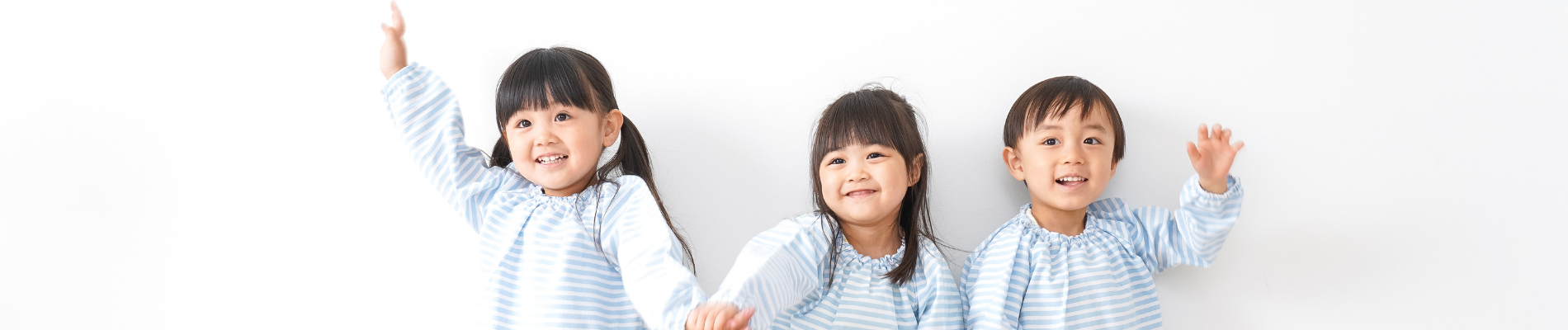 trois enfants souriants et se tenant la main