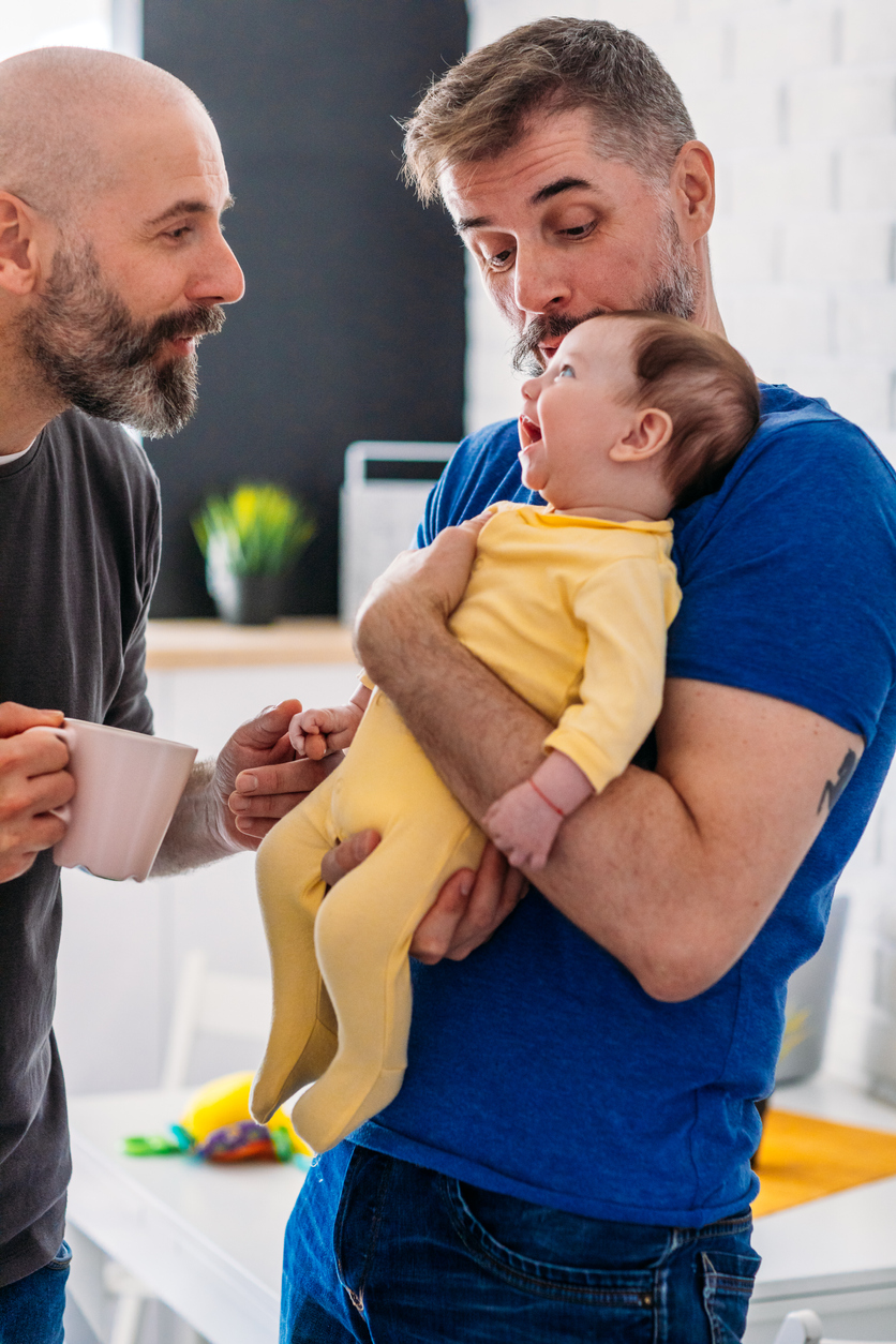 2 Dads with smiling baby