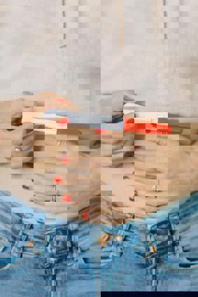 individual touching their stomach and holding pregnancy test