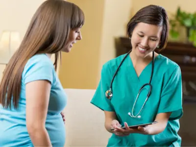 Health-care practitioner and pregnant individual talking